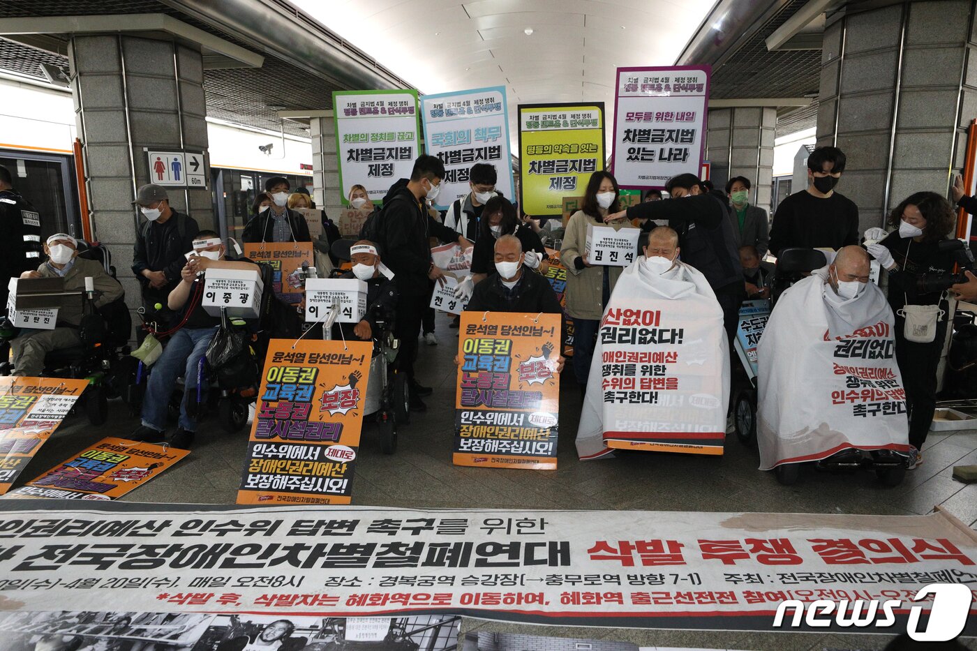 본문 이미지 - 전국장애인차별철폐연대(전장연) 회원들이 20일 오전 서울 경복궁역 3호선 승강장에서 기자회견을 갖고 대통령직 인수위원회의 장애인권리예산 확보를 촉구하며 삭발하고 있다. 2022.4.20/뉴스1 ⓒ News1 신웅수 기자
