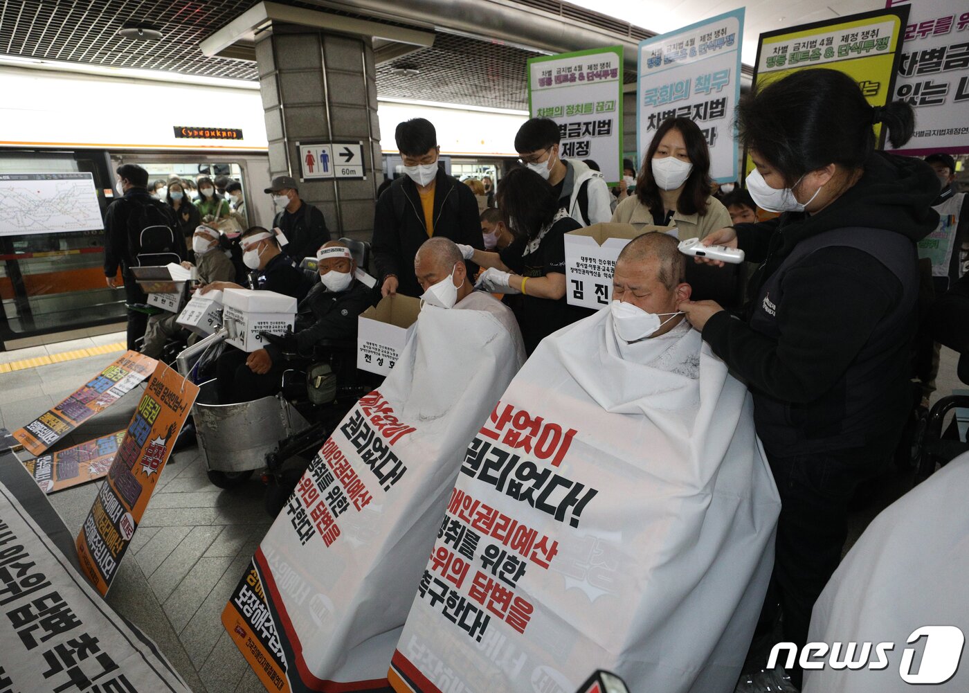 본문 이미지 - 전국장애인차별철폐연대(전장연) 회원들이 20일 오전 서울 경복궁역 3호선 승강장에서 기자회견을 갖고 대통령직 인수위원회의 장애인권리예산 확보를 촉구하며 삭발하고 있다. 2022.4.20/뉴스1 ⓒ News1 신웅수 기자