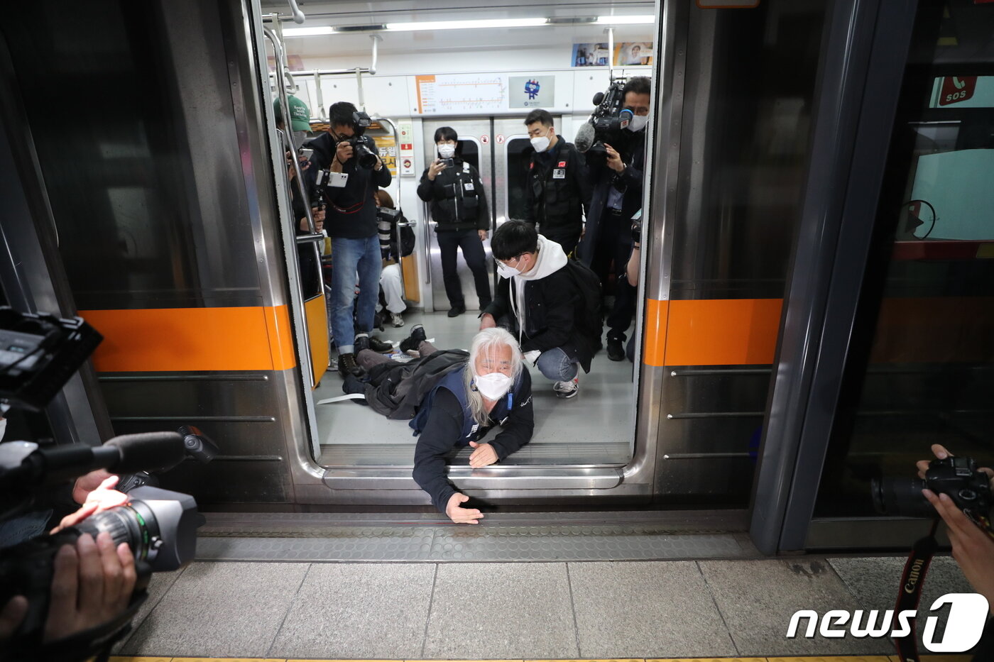 본문 이미지 - 박경석 전국장애인차별철폐연대(전장연) 공동대표가 21일 오전 서울 경복궁역 3호선 열차에서 장애인권리예산 확보 및 장애인 이동권 보장 촉구 시위를 펼치고 있다. 2022.4.21/뉴스1 ⓒ News1 구윤성 기자