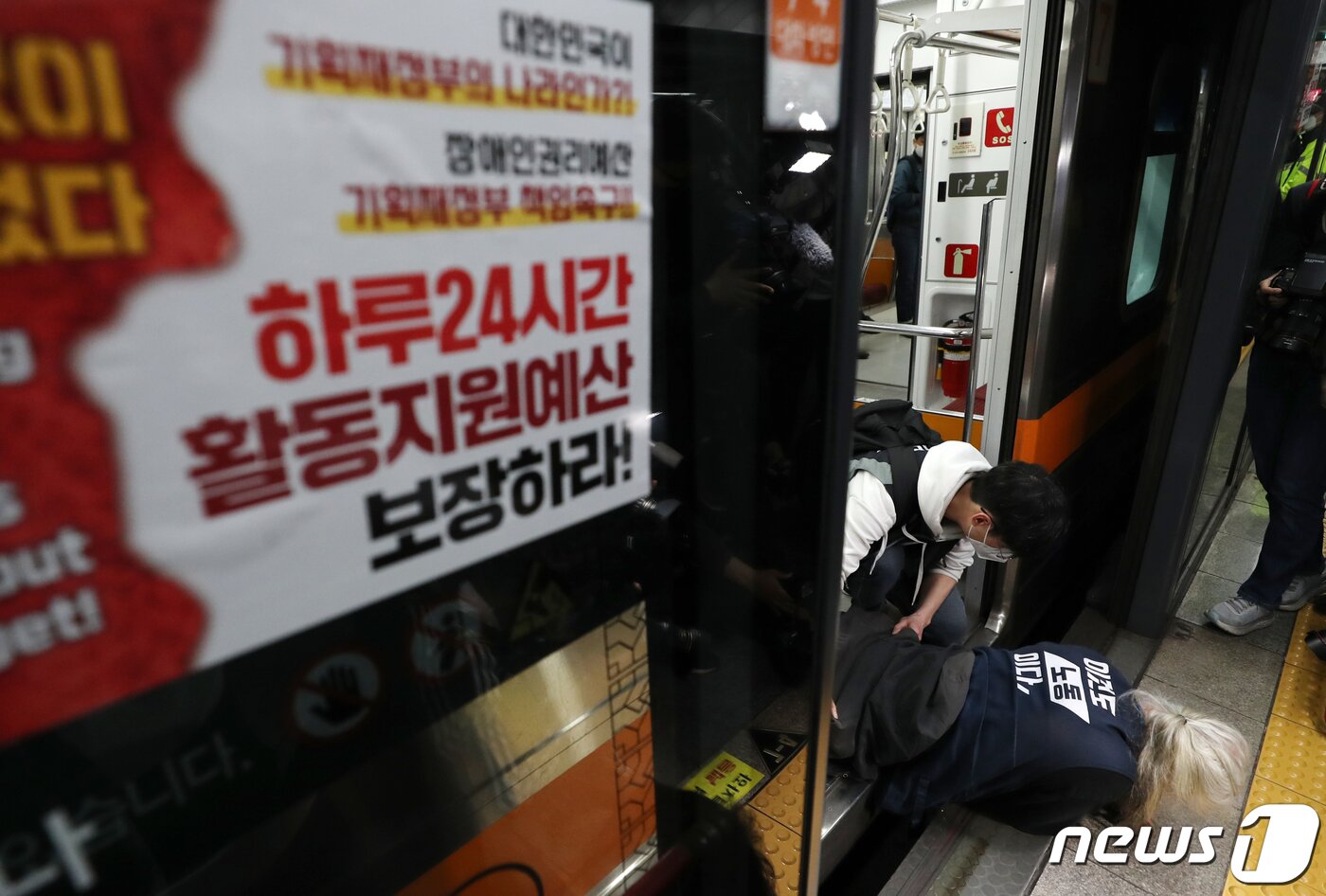 본문 이미지 - 박경석 전국장애인차별철폐연대(전장연) 상임공동대표가 21일 오전 서울 경복궁역 3호선 열차에서 장애인권리예산 확보 및 장애인 이동권 보장 촉구 시위를 펼치고 있다. 2022.4.21/뉴스1 ⓒ News1 구윤성 기자