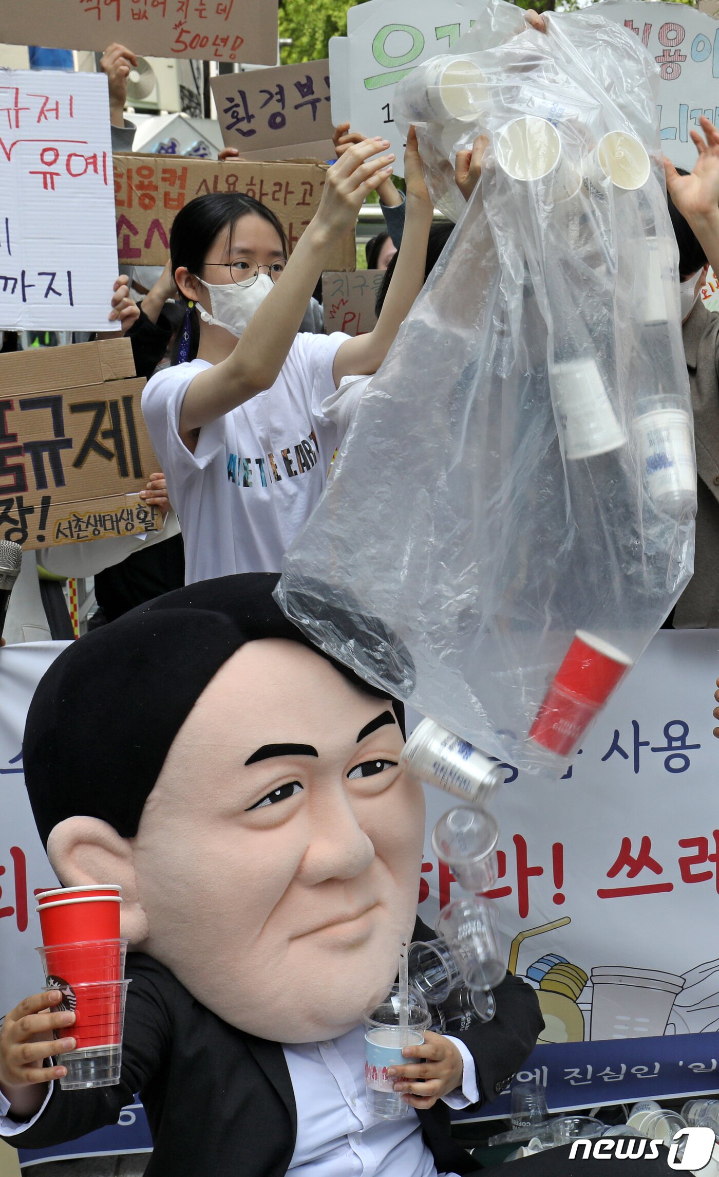 본문 이미지 - '일회용품과 쓰레기 문제 해결에 진심인 일진들' 관계자들이 지구의날을 하루 앞둔 21일 서울 종로구 대통령직 인수위원회 앞에서 식품접객업 매장 내 1회용품 규제의 완전한 시행 촉구 퍼포먼스를 펼치고 있다. 2022.4.21/뉴스1 ⓒ News1 이성철 기자