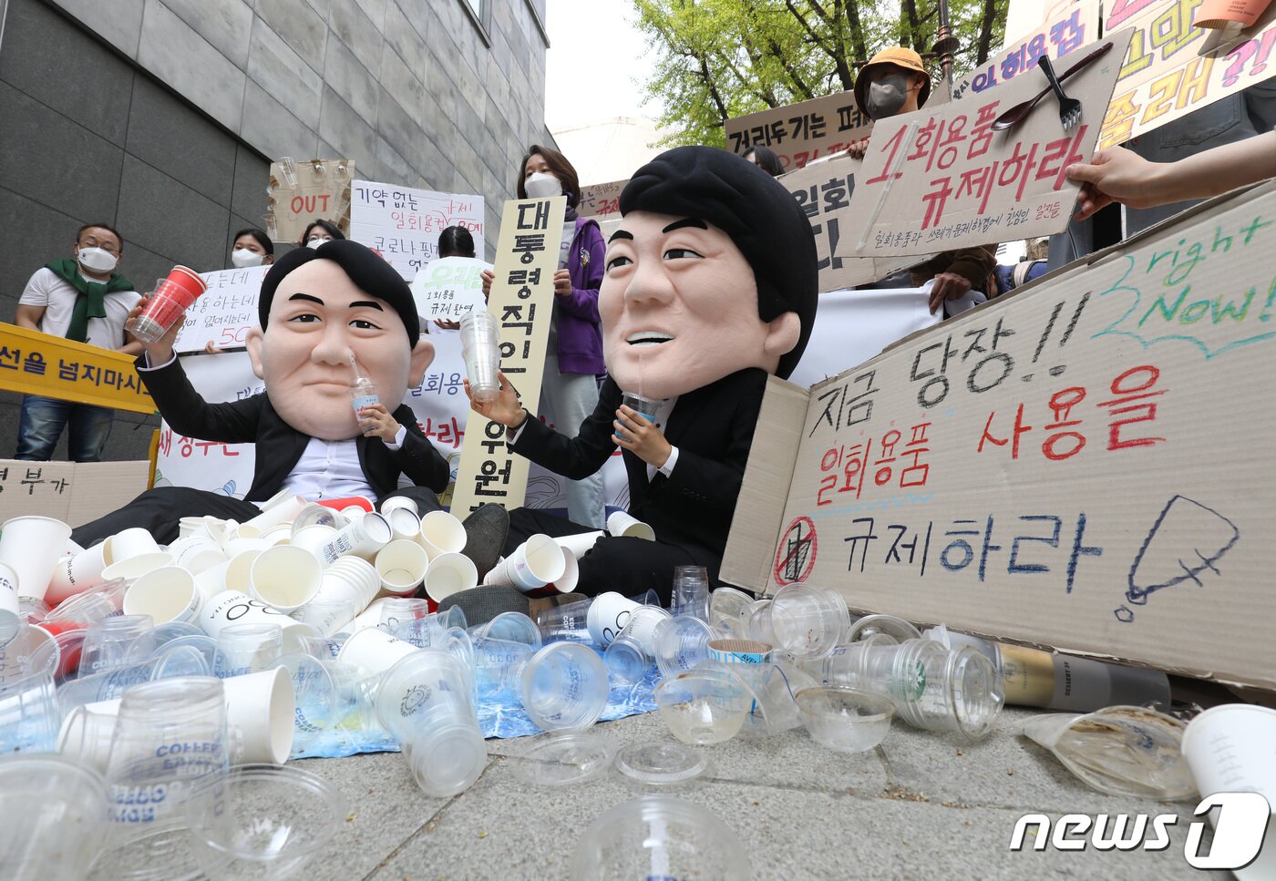 본문 이미지 - '일회용품과 쓰레기 문제 해결에 진심인 일진들' 관계자들이 지구의날을 하루 앞둔 21일 서울 종로구 대통령직 인수위원회 앞에서 식품접객업 매장 내 1회용품 규제의 완전한 시행 촉구 퍼포먼스를 펼치고 있다. 2022.4.21/뉴스1 ⓒ News1 이성철 기자