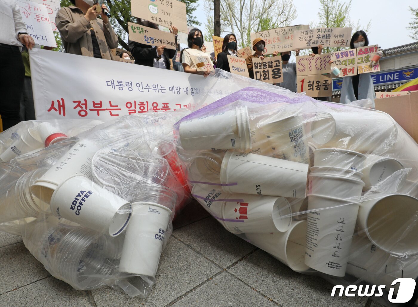 본문 이미지 - '일회용품과 쓰레기 문제 해결에 진심인 일진들' 관계자들이 지구의날을 하루 앞둔 21일 서울 종로구 대통령직 인수위원회 앞에서 식품접객업 매장 내 1회용품 규제의 완전한 시행 촉구 기자회견을 하고 있다. 2022.4.21/뉴스1 ⓒ News1 이성철 기자
