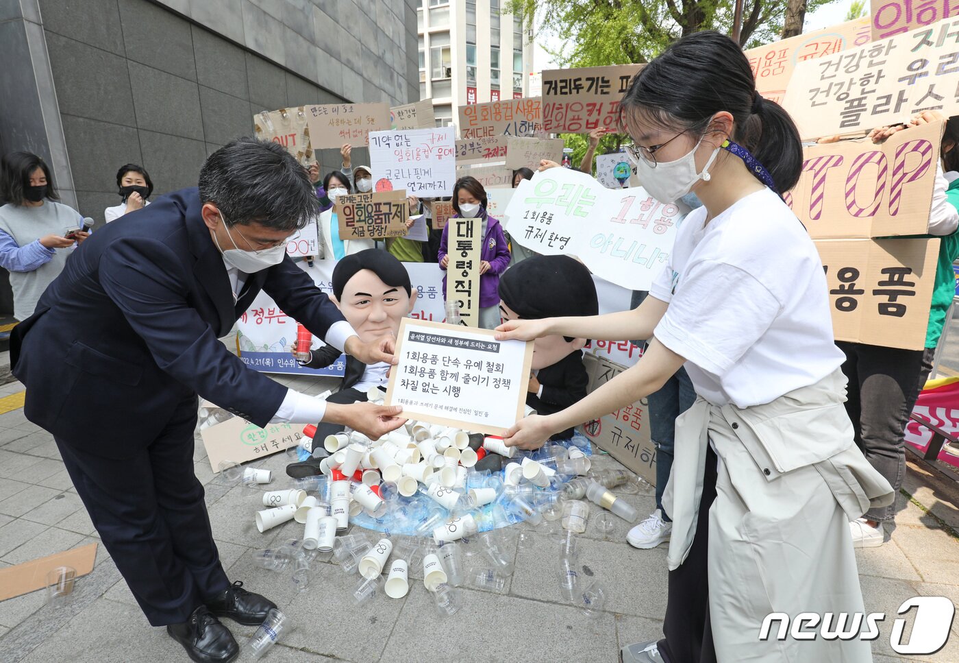 본문 이미지 - '일회용품과 쓰레기 문제 해결에 진심인 일진들' 관계자들이 지구의날을 하루 앞둔 21일 서울 종로구 대통령직 인수위원회 앞에서 1회용품 단속 유예 철회를 요구하는 요청서를 인수위 관계자에게 전달하고 있다. 2022.4.21/뉴스1 ⓒ News1 이성철 기자
