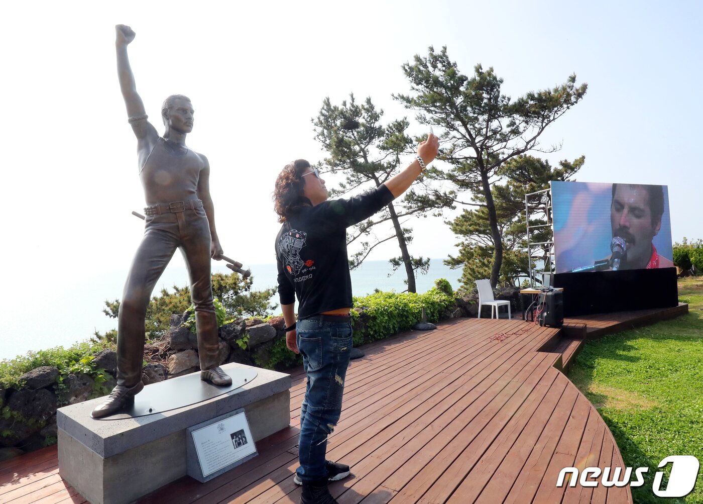 본문 이미지 - 21일 오후 제주시 애월읍에 위치한 해안가 언덕에서 진행된 퀸 프레디 머큐리 기념 공인 동상 제막식에서 팬이 기념사진을 찍고 있다. 2022.4.21/뉴스1 ⓒ News1 오현지 기자