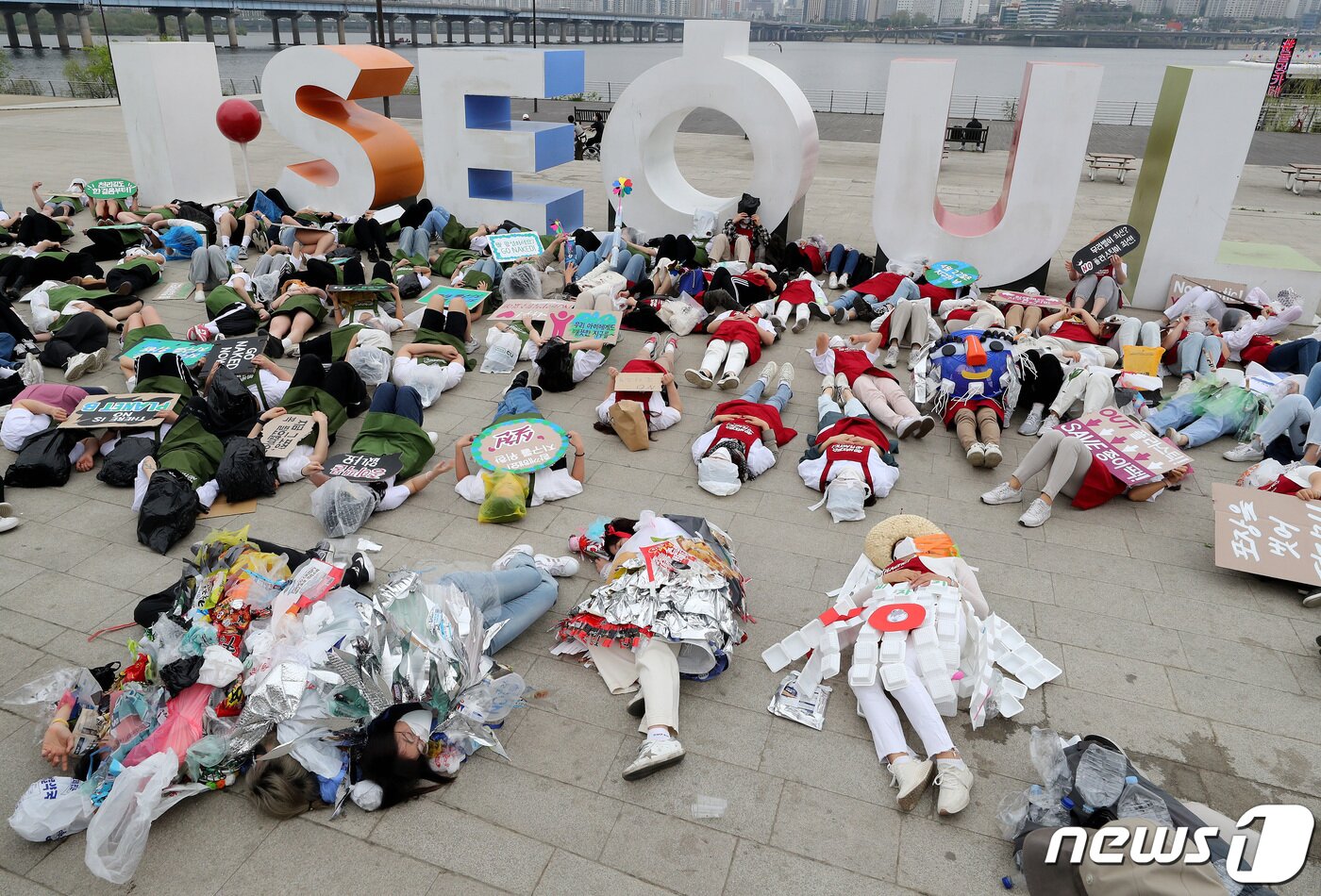 본문 이미지 - 시민활동가들이 22일 서울 영등포구 여의도 한강공원에서 지구의 날을 맞아 플라스틱 등 일회용 포장제 쓰레기를 줄이기 위한 '고 네이키드, 노 플라스틱' 캠페인에서 퍼포먼스를 펼치고 있다. 2022.4.22/뉴스1 ⓒ News1 이동해 기자