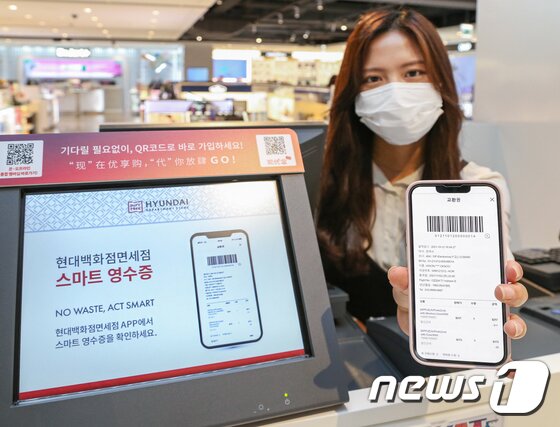 본문 이미지 - 현대백화점면세점에서 직원이 스마트 영수증 서비스를 소개하고 있는 모습.ⓒ 뉴스1 DB