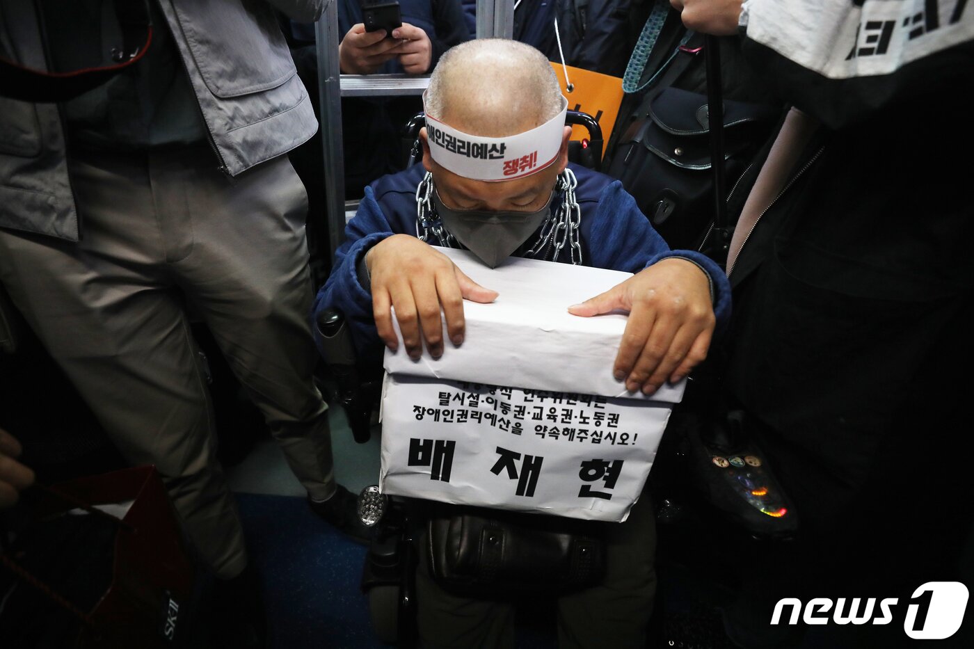 본문 이미지 - 목에 쇠사슬을 묶은 배재현 전국장애인차별철폐연대 활동가가 4일 오전 서울 종로구 지하철3호선 경복궁역에서 장애인 이동권 및 예산 확보를 위한 기자회견을 마치고 4호선 혜화역으로 이동을 하고 있다. 전장연은 인수위에 장애인 평생교육 및 특별교통수단(장애인 콜택시) 운영비 국고 지원, 하루 24시간 활동 지원, 탈시설 권리예산 788억원 보장 등을 요구하고 있다. 2022.4.4/뉴스1 ⓒ News1 송원영 기자