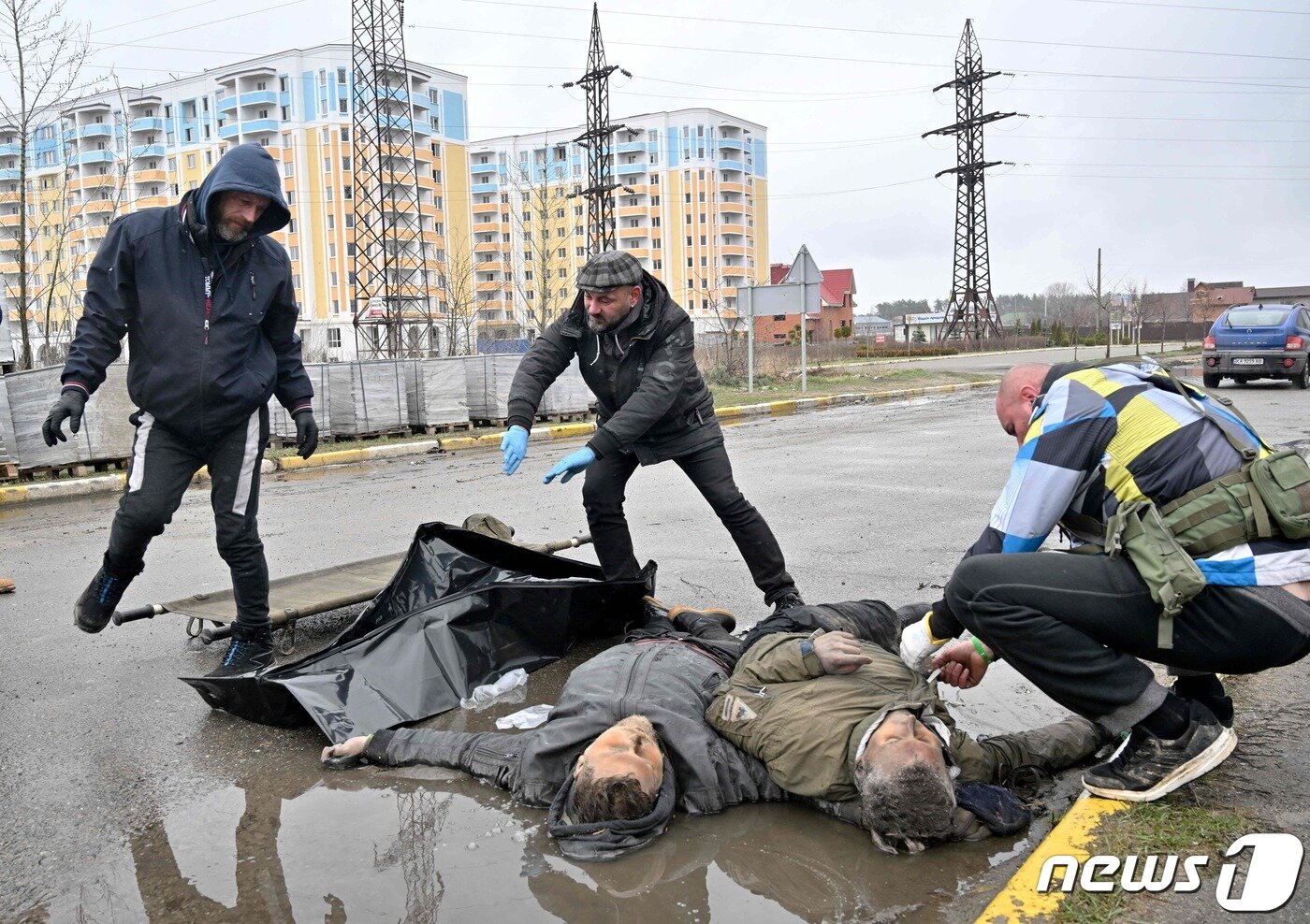 본문 이미지 - 3일(현지시간) 우크라이나 수도 키이우 인근 부차 거리에서 러시아 군에 의해 숨진 주민들을 근로자들이 수습을 하고 있다. ⓒ AFP=뉴스1 ⓒ News1 우동명 기자