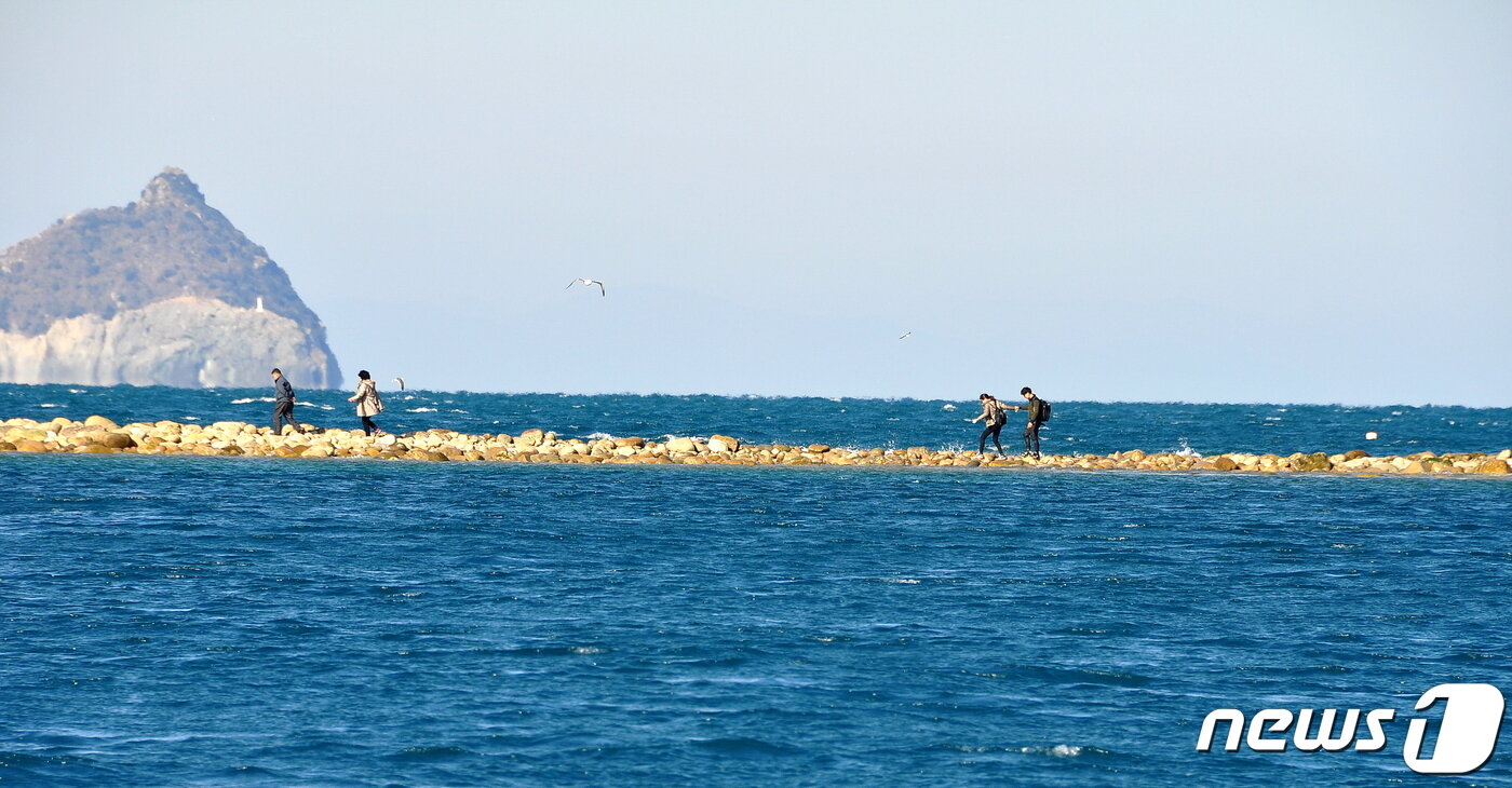 본문 이미지 - 길이 열려 열목개의 몽돌길을 건너가는 사람들. 누구나 어린아이처럼 즐거운 표정이다. ⓒ 뉴스1