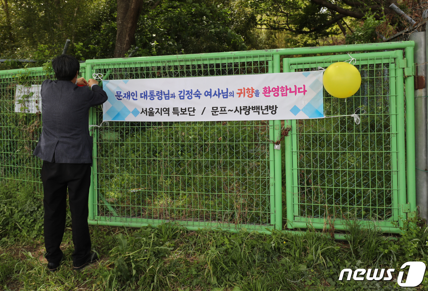 (양산=뉴스1) 김영훈 기자 = 문재인 전 대통령 내외 귀향일인 10일 경남 양산 하북면 평산마을회관 앞에서 지지자가 문 전 대통령을 환영하는 현수막을 걸고 있다. 2022.5.1 …
