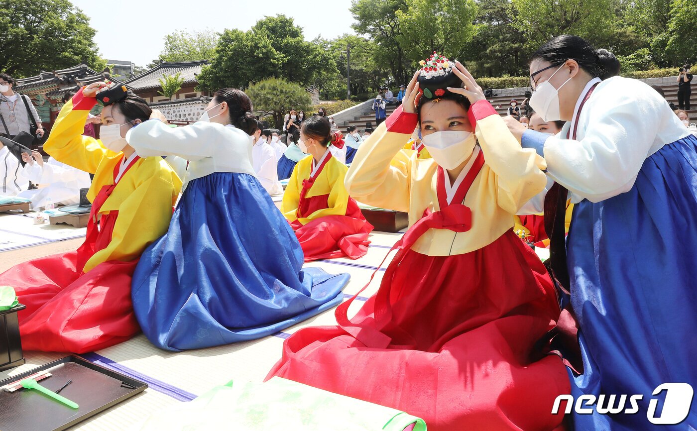 본문 이미지 - 성년의날인 16일 서울 중구 남산골한옥마을에서 열린 '서울시 성년의 날 기념행사'에서 만19세가 된 2003년생들이 의복 및 비녀, 족두리를 착용하는 가례 의식을 하고 있다. 2022.5.16/뉴스1 ⓒ News1 임세영 기자