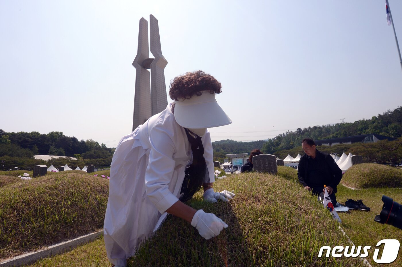 본문 이미지 - 5·18민주화운동 제42주년을 하루 앞둔 17일 광주 북구 운정동 국립5·18민주묘지를 찾은 한 유족이 묘지를 돌보고 있다. 2022.5.17/뉴스1 ⓒ News1 정다움 기자
