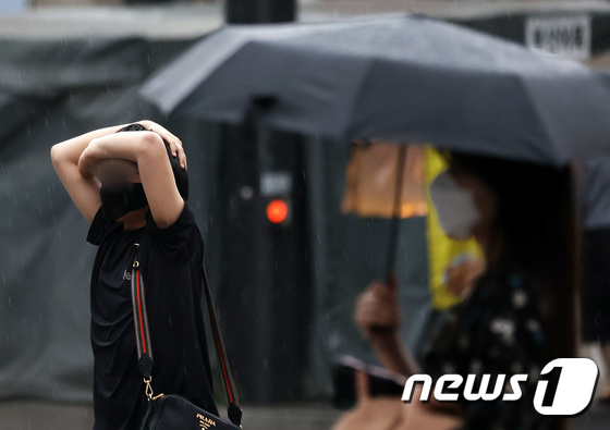 소나기가 내린 지난 18일 오전 서울 시내에서 시민들이 비를 피하기 위해 발걸음을 재촉하고 있다. 2022.5.18/뉴스1 © News1 조태형 기자