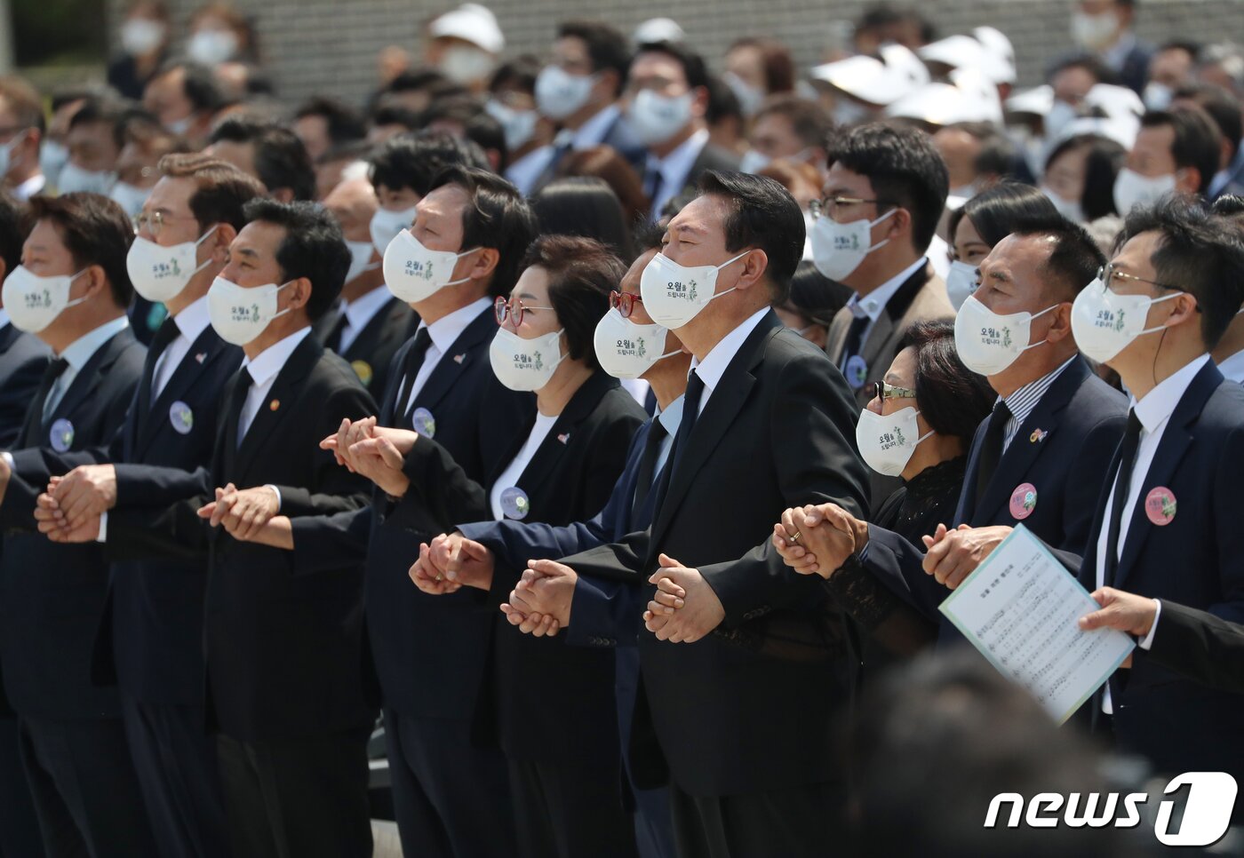 본문 이미지 - 윤석열 대통령이 18일 오전 광주 북구 국립 5·18 민주묘지에서 제42주년 5·18민주화운동 기념식에 참석해 '임을 위한 행진곡'을 제창하고 있다. 제창시 손을 잡거나, 주먹을 쥐고 부르는 모습이 대비를 보인다.(공동취재) 2022.5.18/뉴스1 ⓒ News1 황희규 기자