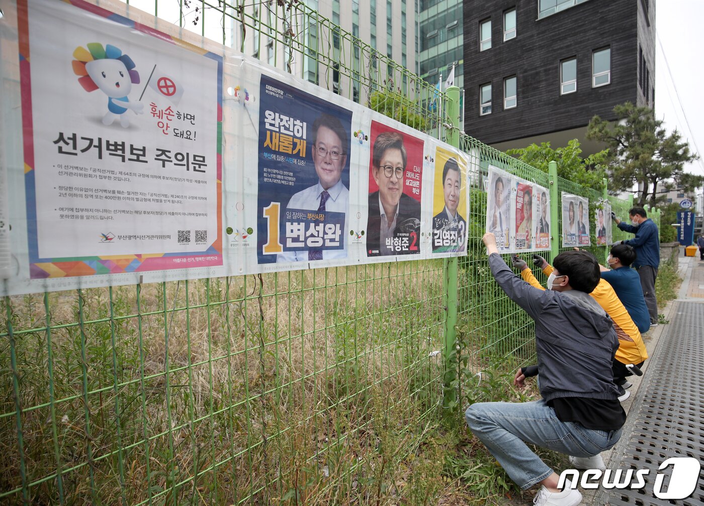 본문 이미지 - 제8회 전국동시지방선거 공식 선거운동 첫날인 19일 부산시 수영구 망미1동 행정복지센터 부근에서 수영구 직원들이 선거벽보를 부착하고 있다. 2022.5.19/뉴스1 ⓒ News1 김영훈 기자