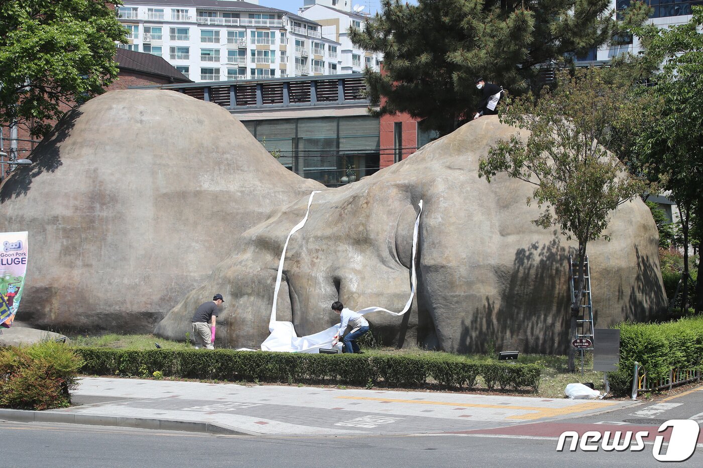 본문 이미지 - 실외 마스크 해제 첫날인 2일 오전 대구 달서구청 관계자들이 달서구 진천동 원시인 조형물에 씌워져 있던 마스크를 벗기고 있다.  2022.5.2/뉴스1 ⓒ News1 공정식 기자