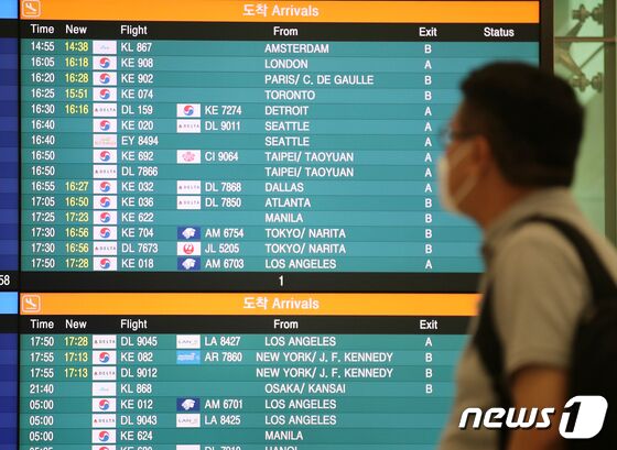 24일 오후 인천국제공항 제2여객터미널에서 출발·도착 현황판 앞으로 이용객들이 오가고 있다. 2022.5.24/뉴스1 © News1 김진환 기자