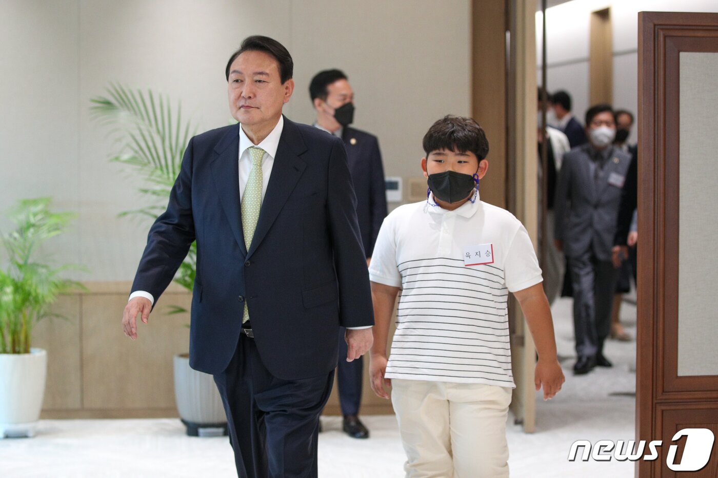 본문 이미지 - 윤석열 대통령이 25일 용산 대통령실에서 국민희망대표 20인을 초청해 대통령 취임 기념 시계를 증정한 뒤 집무실 내부를 직접 소개하기 위해 입장하고 있다. 오른쪽은 3년간 용돈 전액(50만원)으로 달걀 기부한 육지승 어린이. (대통령실사진기자단) 2022.5.25/뉴스1 ⓒ News1 안은나 기자