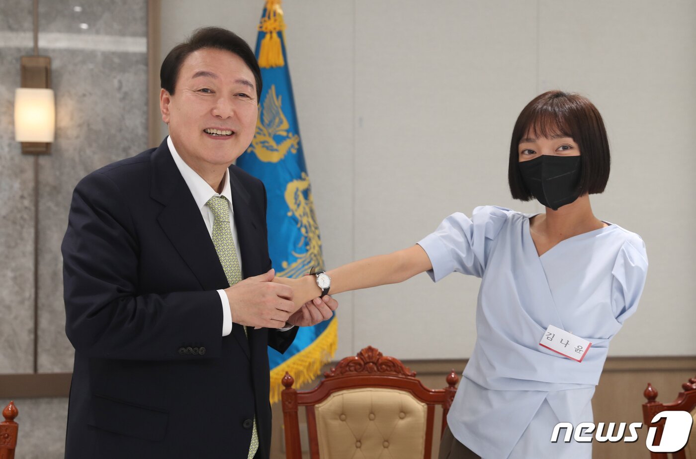 본문 이미지 - 윤석열 대통령이 25일 용산 대통령실 집무실에서 취임식에 참석했던 국민대표 20인에게 대통령 기념시계를 선물하고 오찬을 함께 했다. 윤 대통령이 한팔 보디빌더로 WBC 피트니스 월드바디 클래식에서 4관왕을 차지한 김나윤씨에게 시계를 채워주고 있다. (대통령실사진기자단) 2022.5.25/뉴스1 ⓒ News1 안은나 기자