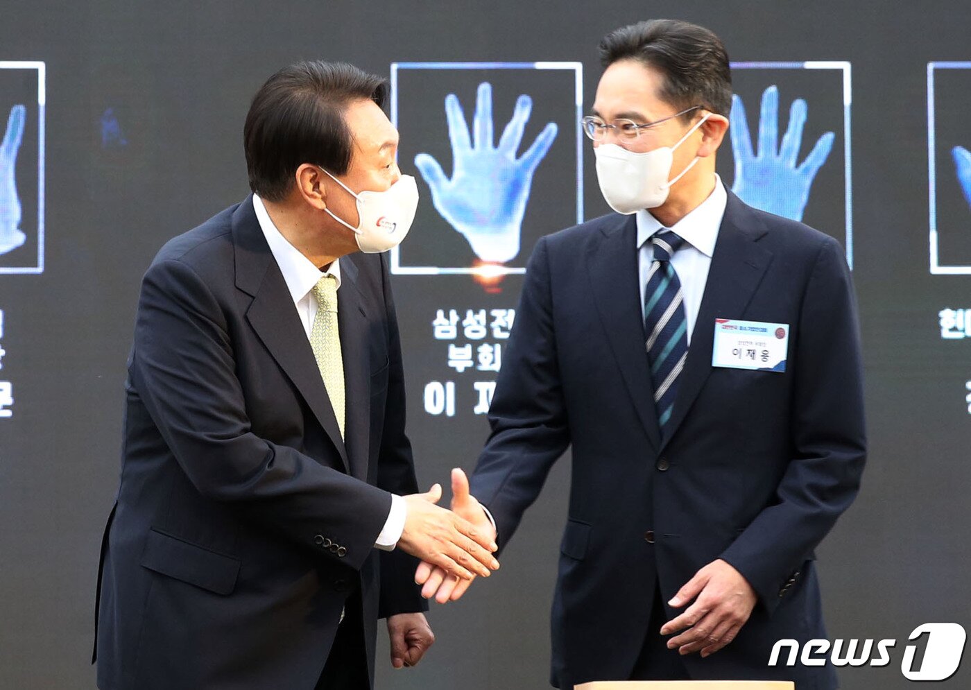 본문 이미지 - 윤석열 대통령이 25일 용산 대통령실 청사 앞 잔디마당에서 열린 2022 대한민국 중소기업인대회에서 핸드프린팅을 마친 이재용 삼성전자 부회장과 악수하고 있다. (대통령실사진기자단) 2022.5.25/뉴스1 ⓒ News1 오대일 기자