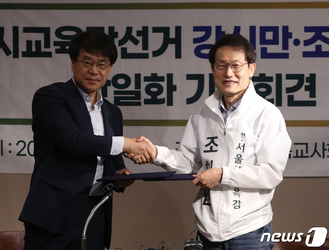 본문 이미지 - 2022년 6·1 전국 동시지방선거에 출마한 조희연 전 서울시교육감과 강신만 전 전교조 부위원장이 사전투표 전날인 5월 26일 단일화에 합의하는 모습. /뉴스1 ⓒ News1 신웅수 기자