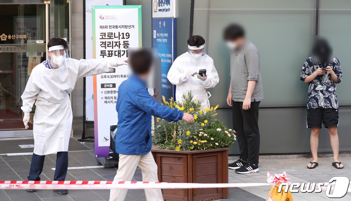 본문 이미지 - 제8회 전국동시지방선거 사전 투표 이틑날인 28일 오후 서울 용산구의회에 마련된 이태원 제1동 사전투표소에서 신종 코로나바이러스 감염증(코로나19)에 확진된 유권자들이 소중한 한 표를 행사하기 위해 사무원들의 안내를 받고 있다.  2022.5.28/뉴스1 ⓒ News1 구윤성 기자