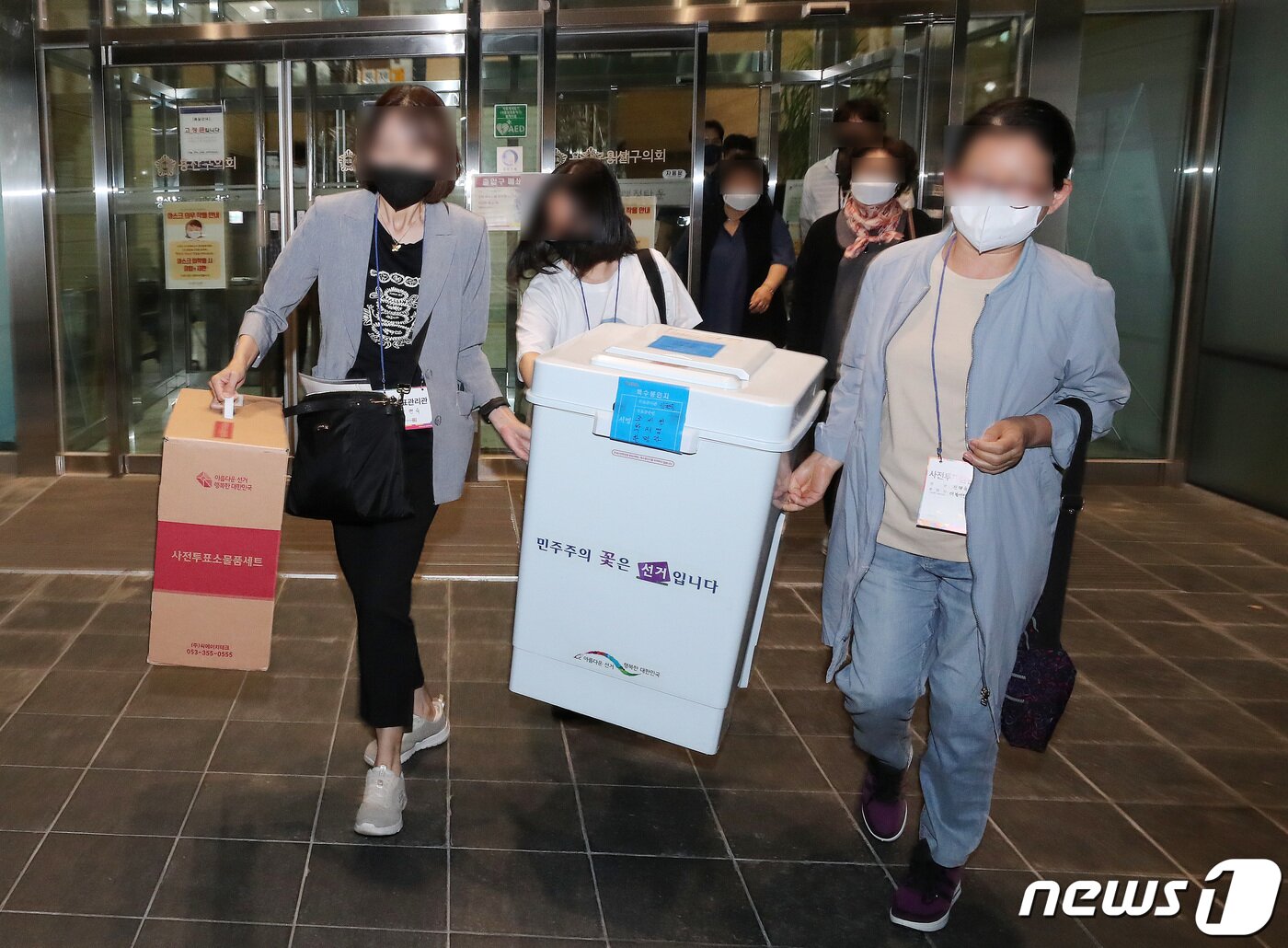 본문 이미지 - 제8회 전국동시지방선거 사전 투표 이틑날인 28일 오후 서울 용산구의회에 마련된 이태원 제1동 사전투표소에서 사무원과 참관인들이 사전투표가 끝난 뒤 수거한 투표함을 이송차량으로 옮기고 있다.  2022.5.28/뉴스1 ⓒ News1 구윤성 기자