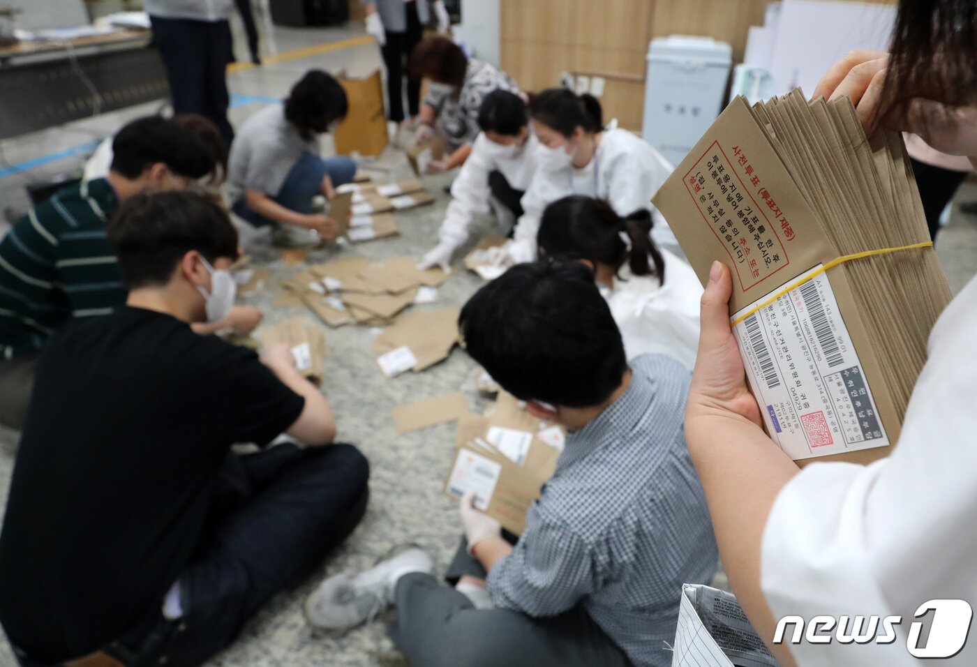 본문 이미지 - 제8회 전국동시지방선거 사전 투표 이틑날인 28일 오후 서울 용산구의회에 마련된 이태원 제1동 사전투표소에서 사무원과 참관인들이 사전투표가 끝난 뒤 관외 사전투표 봉투를 분류하고 있다. 2022.5.28/뉴스1 ⓒ News1 구윤성 기자