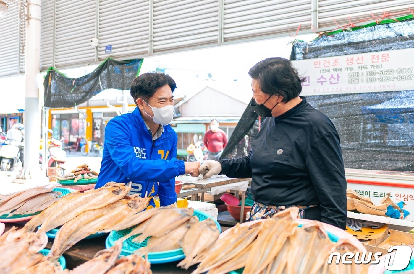 본문 이미지 - 김대중 전남교육감 후보가 시장에서 주민과 인사하고 있다.ⓒ 뉴스1