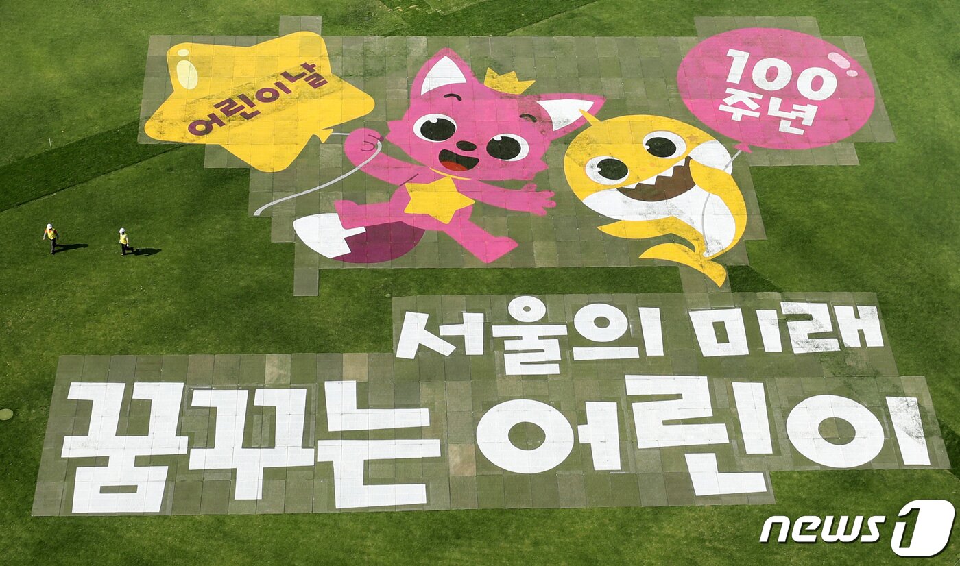 본문 이미지 - 어린이날을 앞둔 3일 오후 서울광장 잔디밭에 인기 캐릭터 핑크퐁·아기상어와 함께 어린이날 100주년 기념 '서울의 미래, 꿈꾸는 어린이'라는 문구가 새겨져 있다. 2022.5.3/뉴스1 ⓒ News1 박지혜 기자