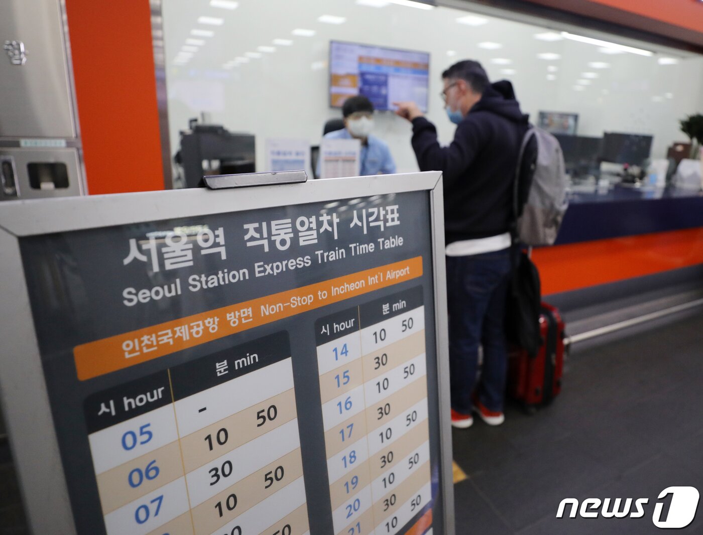 본문 이미지 - 서울역 도심공항터미널에 한 외국인 관광객이 공항철도 직통열차 안내센터에서 직원에게 도움을 받고 있다. 2022.5.30/뉴스1 ⓒ News1 김진환 기자