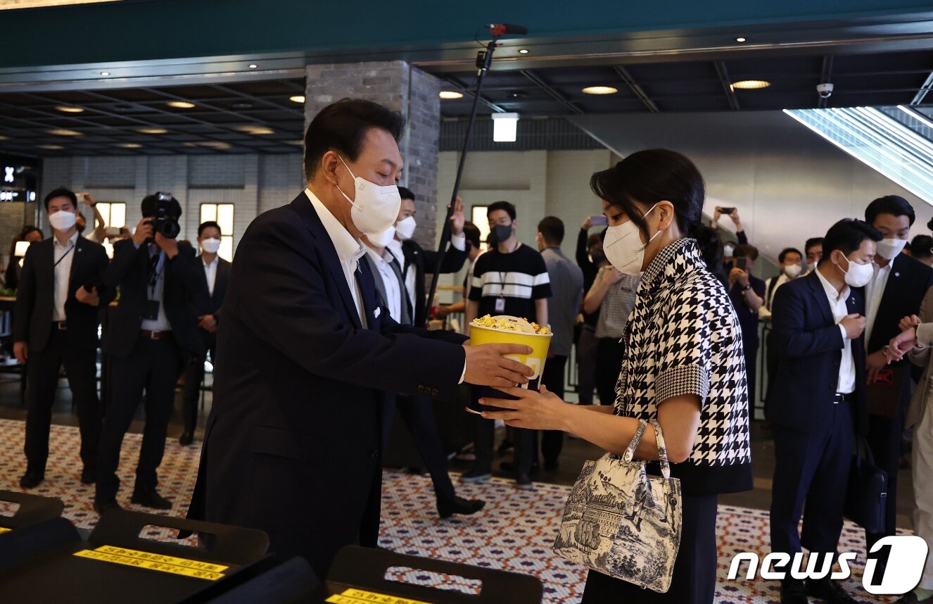 본문 이미지 - 윤석열 대통령이 12일 오후 서울 메가박스 성수점에서 제75회 칸 국제영화제 남우주연상(송강호) 수상작 영화 '브로커'를 관람하기 전 부인 김건희 여사에게 팝콘을 주고 있다. (대통령실 제공) 2022.6.12/뉴스1 ⓒ News1 안은나 기자