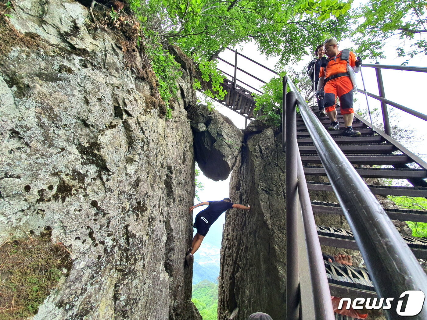본문 이미지 - 철계단 옆 절벽 사이에 낀 바위. 사진포즈를 잡으려는 사람이 위험스럽다 ⓒ 뉴스1