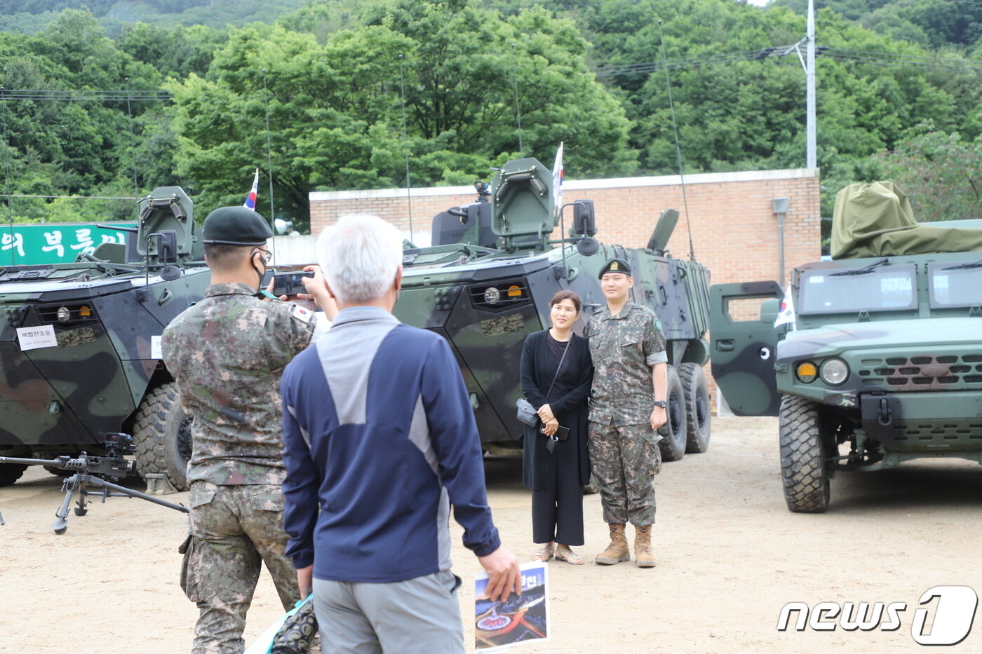 본문 이미지 - 수료 신병들이 가족, 전우와 함께 전시된 장비(K808) 앞에서 사진 촬영하고 있다.(육군 7사단 제공) 2022.6.15/뉴스1