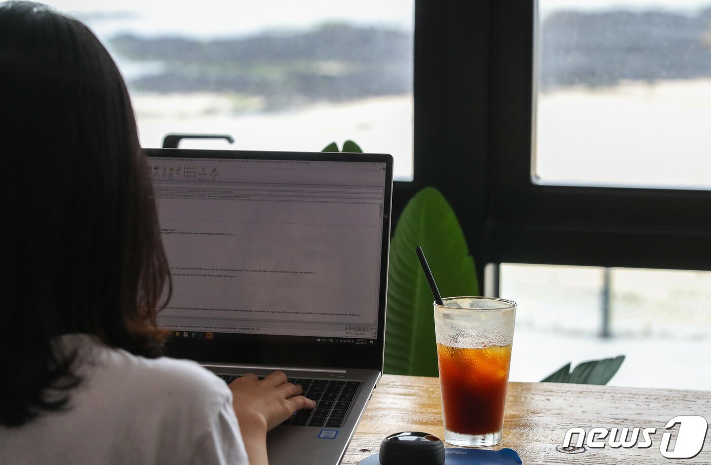 본문 이미지 - 제주 질그랭이센터 공유오피스에서 워케이션을 온 업체 직원이 바다를 감상하며 일을 하고 있다ⓒ 뉴스1