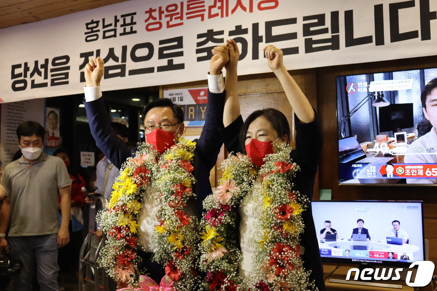 본문 이미지 - 경남 창원시장 선거에 나선 홍남표 국민의힘 후보가 당선이 확실시 되자 꽃다발을 목에 걸고 손을 번쩍 들어보이고 있다.(홍 후보 선거사무소 제공)ⓒ 뉴스1