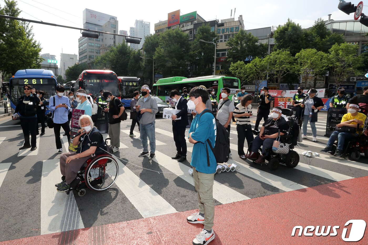 본문 이미지 - 박경석 전국장애인차별철폐연대(전장연) 상임공동대표와 활동가들이 2일 장애인 권리예산과 이동권 보장을 촉구하며 회현역을 출발해 남대문시장에서 서울시의회 방향으로 행진 중 횡단보도에서 발언을 하고 있다. 2022.6.2/뉴스1 ⓒ News1 박세연 기자