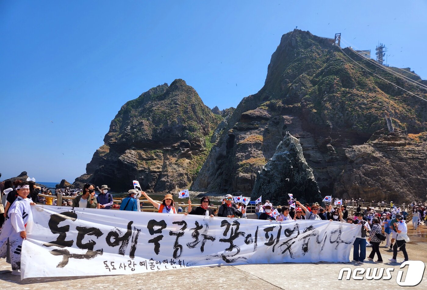 본문 이미지 - 독도사랑예술인연합회 김지영 회장과 전통 춤꾼 김옥순, 서예가 김동욱씨가 2일 우리 땅 독도에서 '무궁화 꽃이 피었습니다'합동 공연을 개최했다. 김 회장 등은 대형 붓으로 독도 수호의지를 표현했고 춤 꾼 김옥순 씨는 봉황춤으로 독도평화를 기원했다. (독도사랑예술인연합회 제공)2022.6.2/뉴스1 ⓒ News1 최창호 기자