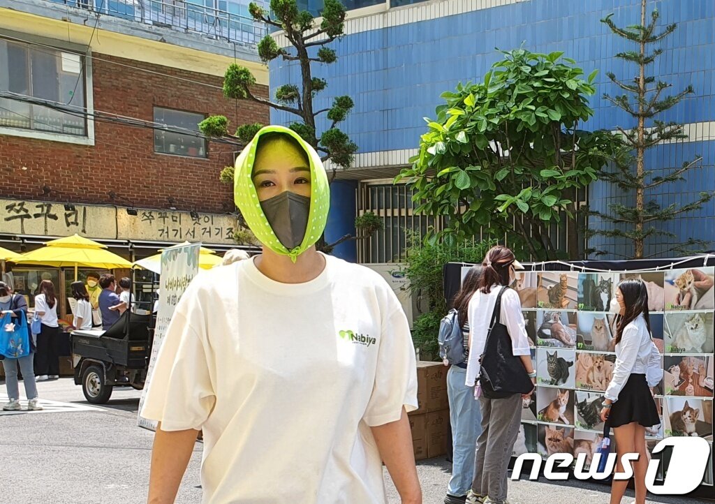 본문 이미지 - 5월 28일 서울 용산구 백범로 일대에서 열린 &#39;나비야사랑해&#39; 바자회에서 더위를 피해 머리에 두건을 쓴 유주연 대표가 환하게 웃고 있다. ⓒ 뉴스1 최서윤 기자