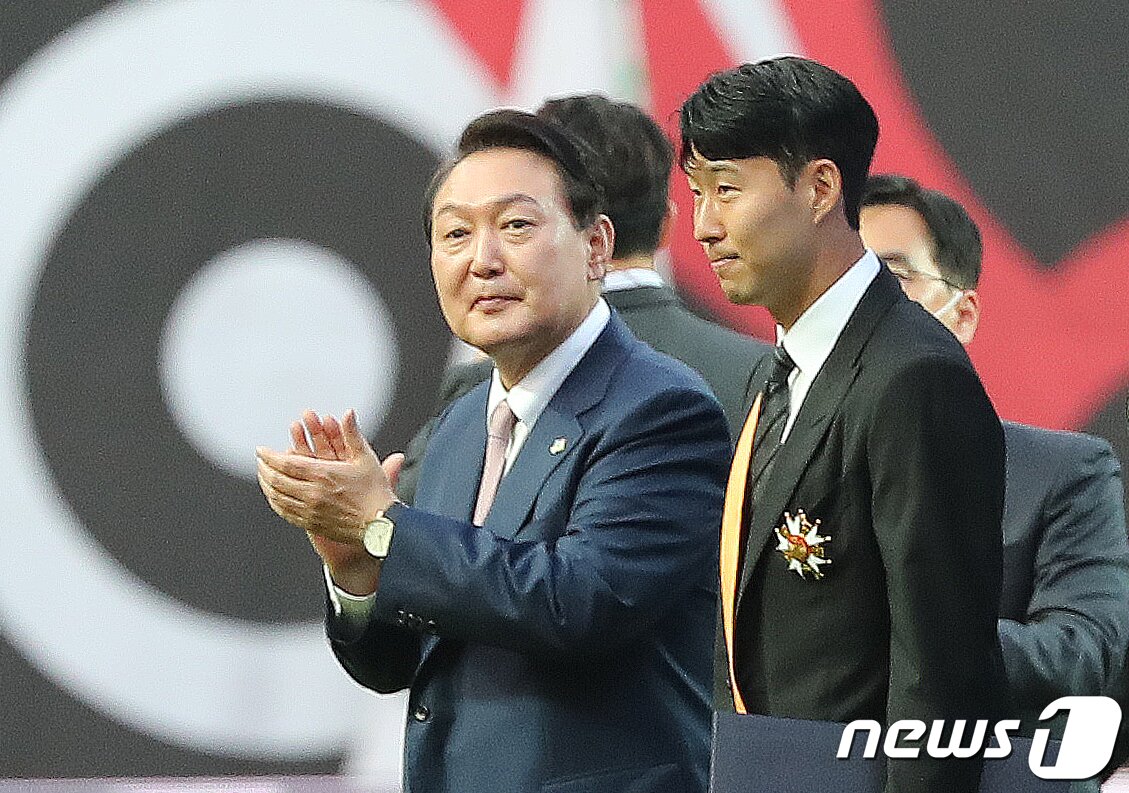 본문 이미지 - 윤석열 대통령이 2일 오후 서울월드컵경기장에서 열리는 2002 한일월드컵 20주년 기념 평가전 대한민국-브라질의 경기에 앞서 잉글랜드 프로축구 프리미어리그(EPL)에서 아시아 선수 최초로 득점왕을 차지한 손흥민에게 체육훈장 최고등급인 청룡장을 수여한 뒤 박수치고 있다. 2022.6.2/뉴스1 ⓒ News1 구윤성 기자