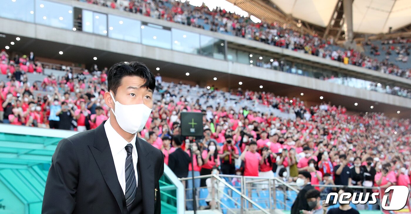 본문 이미지 - 잉글랜드 프로축구 프리미어리그(EPL)에서 아시아 선수 최초로 득점왕을 차지한 손흥민이 2일 서울월드컵경기장에서 2002 한일월드컵 20주년 기념 평가전 대한민국-브라질의 경기에 앞서 윤석열 대통령으로부터 체육훈장 최고등급인 청룡장을 수여받기 위해 그라운드에 들어서고 있다. 대통령실사진기자단 2022.6.2/뉴스1 ⓒ News1 오대일 기자