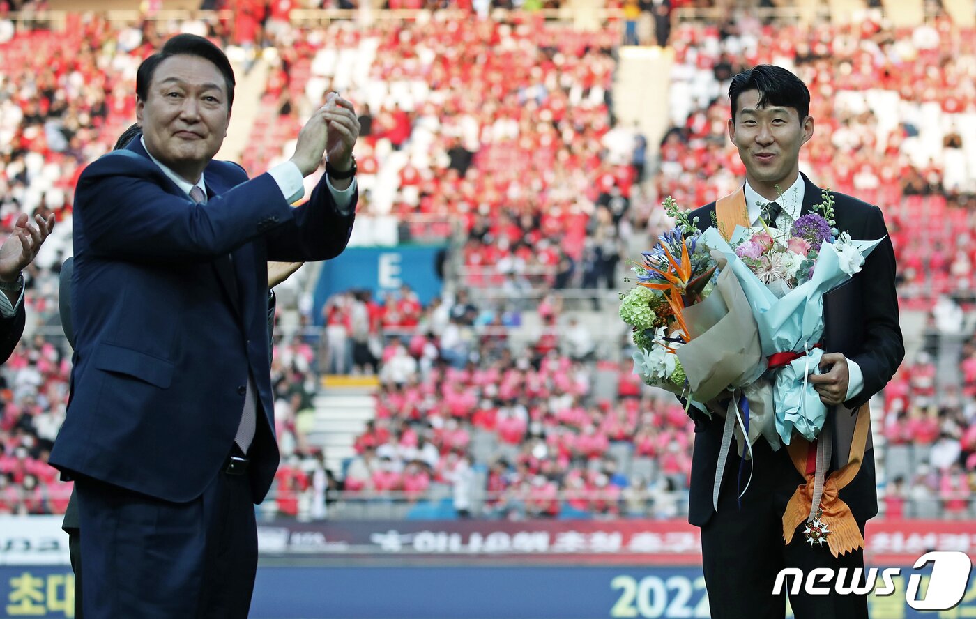 본문 이미지 - 윤석열 대통령이 2일 서울월드컵경기장에서 열린 2002한일월드컵 20주년 기념 대한민국과 브라질 축구 국가대표팀 친선경기에 앞서 잉글랜드 프로축구 프리미어리그(EPL)에서 아시아 선수 최초로 득점왕을 차지한 손흥민에게 체육훈장 청룡장을 수여한 후 박수를 보내고 있다. 대통령실사진기자단 2022.6.2/뉴스1 ⓒ News1 오대일 기자