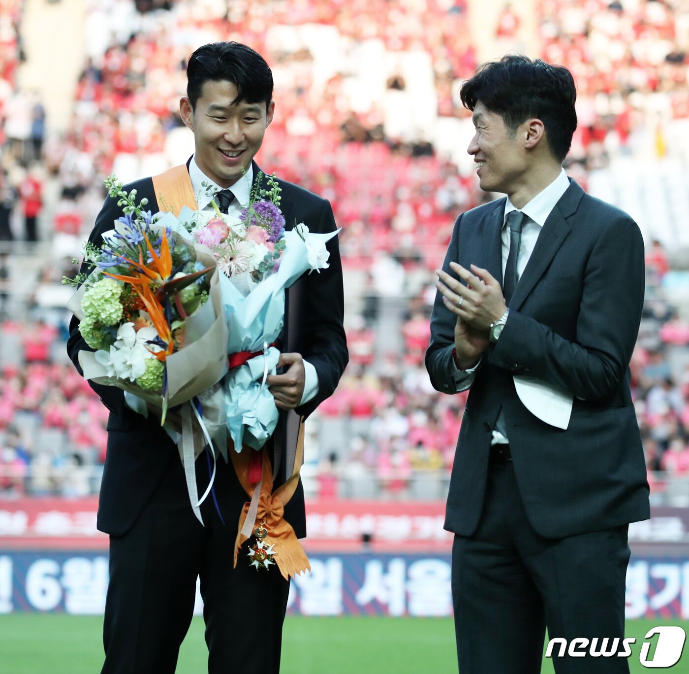 본문 이미지 - 잉글랜드 프로축구 프리미어리그(EPL)에서 아시아 선수 최초로 득점왕을 차지한 손흥민이 2일 서울월드컵경기장에서 2002 한일월드컵 20주년 기념 평가전 대한민국-브라질의 경기에 앞서 윤석열 대통령으로부터 체육훈장 최고등급인 청룡장을 수여받은 뒤 박지성에게 축하받고 있다. 대통령실사진기자단 2022.6.2/뉴스1 ⓒ News1 오대일 기자