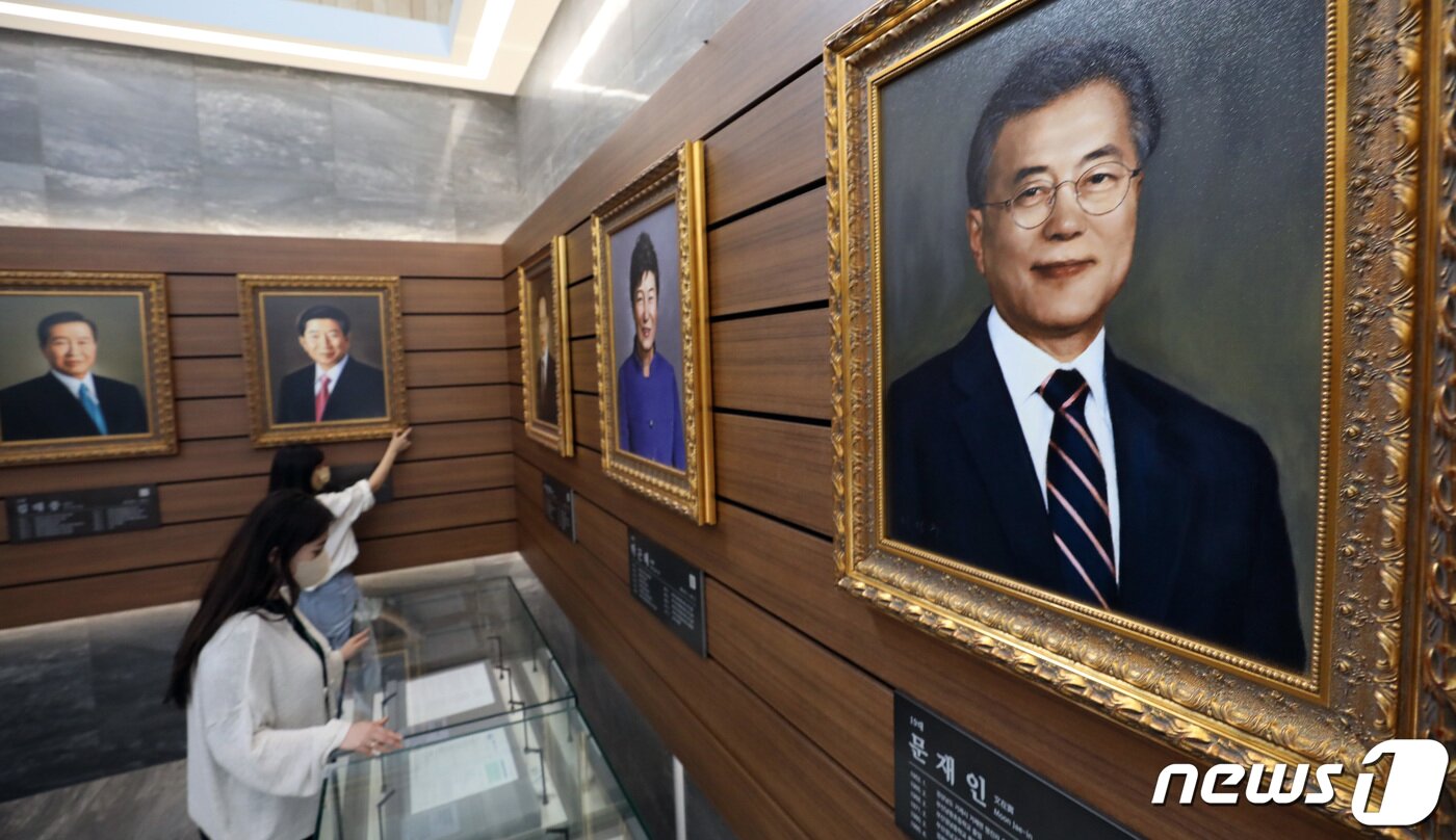 본문 이미지 - 문재인 전 대통령의 주요 기록물이 오는 21일 부터 세종시 대통령기록관에서 일반에 공개된다. 20일 오후 세종시 어진동 대통령 기록관 관계자들이 역대 대통령들의 초상화를 비롯한 자료의 전시를 준비하며 살펴보고 있다.2022.6.20/뉴스1 ⓒ News1 김기남 기자