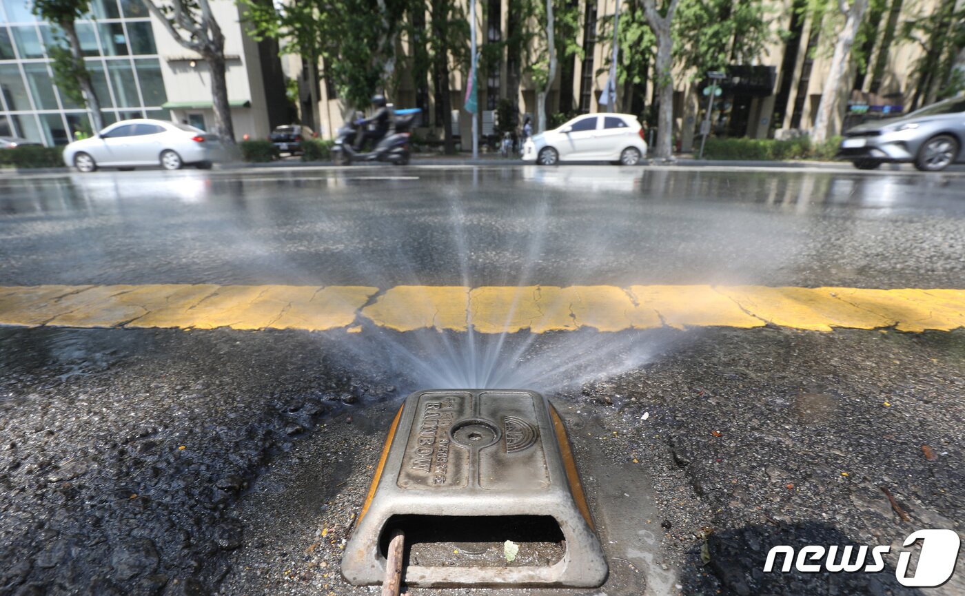 본문 이미지 - 절기상 하지(夏至)인 21일 대구·경북 곳곳에 폭염특보가 발효된 가운데 대구 중구 달구벌대로에 클린로드 시스템(도로 살수 장치)이 가동돼 폭염에 뜨거워진 도로를 식히고 있다. 대구시는 안전한 여름 나기를 위해 클린로드 시스템 운영(평일 2회, 폭염 4회)과 쿨링포그 가동(89개소), 주요 교차로 그늘막 설치(561개소), 쿨루프 설치(24개소) 등 다양한 폭염 경감 대책을 추진한다. 2022.6.21/뉴스1 ⓒ News1 공정식 기자