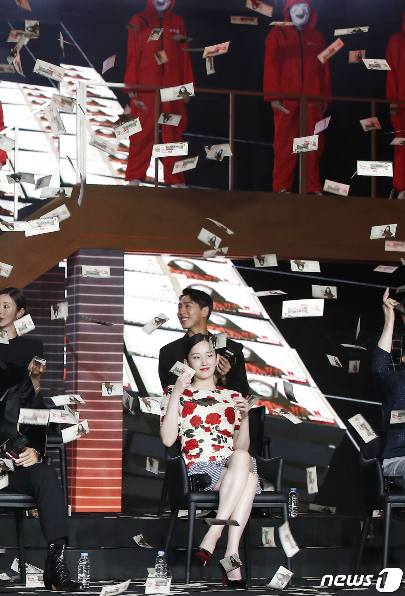 본문 이미지 - 배우 전종서가 22일 오전 서울 강남구 코엑스 그랜드볼룸에서 열린 넷플릭스 시리즈 '종이의 집:공동경제구역' 제작발표회에서 떨어지는 통일 화폐를 들고 미소를 짓고 있다.  ⓒ News1 권현진 기자