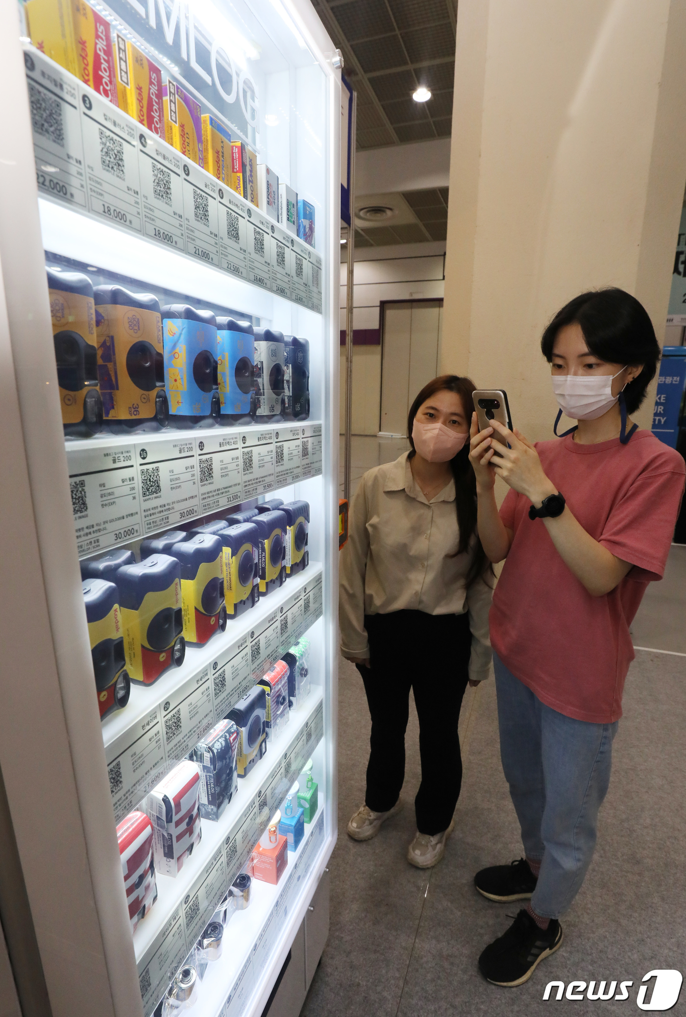 (서울=뉴스1) 송원영 기자 = 23일 서울 강남구 코엑스 A홀에서 열린 제37회 서울국제관광전에서 참석자들이 필름로그 현상소 부스에서 필름카메라 자판기를 살펴보고 있다.  문화체 …