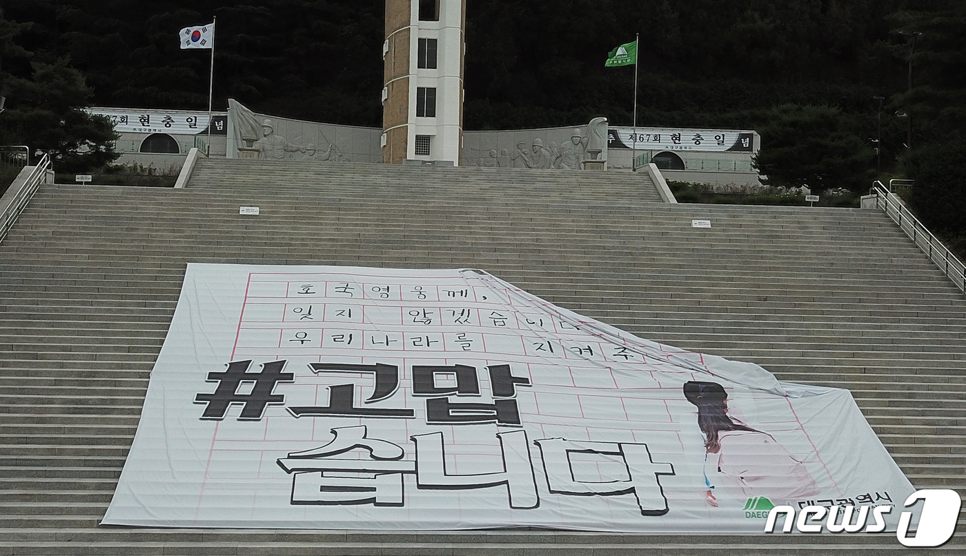 (대구=뉴스1) 공정식 기자 = 6.25전쟁 72주년을 하루 앞둔 24일 오후 대구 남구 대명동 충혼탑 계단에 호국보훈의 달을 맞아 이달 설치된 대형 현수막의 한쪽 고정 장치가 파 …