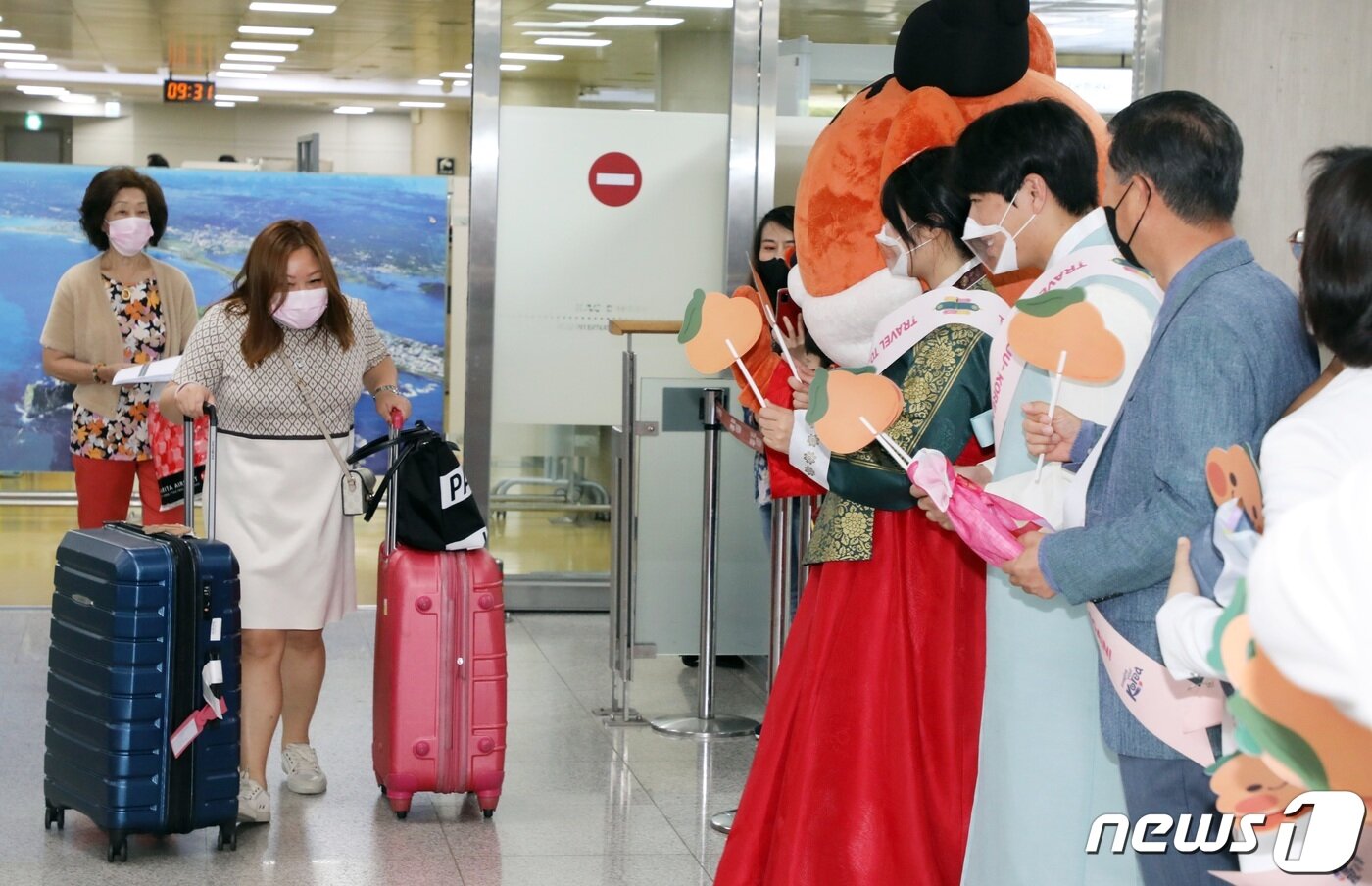 본문 이미지 - 3일 오전 제주국제공항 국제선 도착장에서 제주도와 제주관광공사 직원 등이 태국 관광객들에게 기념품을 나눠주고 있다. 지난 1일자로 제주 무사증(무비자) 일시 정지가 해제돼 2년여 만에 제주공항 국제선이 재개, 외국인 관광객이 인천공항을 거치지 않고 제주로 직접 입도할 수 있게 됐다. 2022.6.3/뉴스1 ⓒ News1 고동명 기자